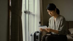 出張から帰宅した夫の搭乗券とキャリーケースを前に思案する妻